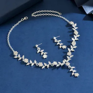 Vista detallada de un conjunto de collar y pendientes de estrás florales plateados para bodas.