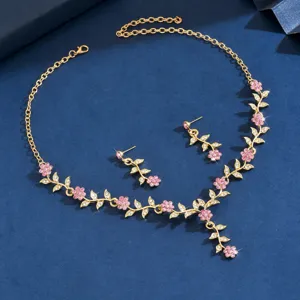 Vista detallada del exquisito conjunto de joyas de collar y pendientes florales dorados.
