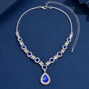 Elegant teardrop crystal necklace detail shot featuring sparkling blue stones and silver chain.