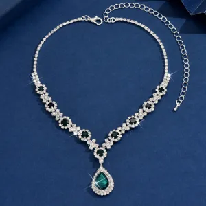 Detailed view of a gorgeous silver rhinestone teardrop necklace with green stone.