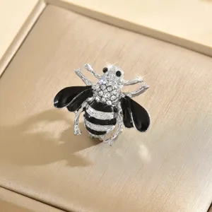 Primo piano dettagliato di una spilla ad ape con strass scintillanti e dettagli in smalto nero.