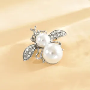 Dettaglio in primo piano della spilla ape perla strass elegante per accessorio da donna.
