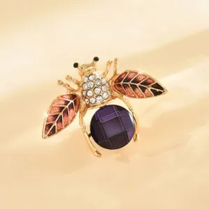 Elegante spilla ad ape in cristallo con ali rosse e pietra viola per eleganti abiti da donna.