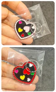 Vue détaillée du pendentif en métal en forme de cœur avec émail coloré et bord ondulé.