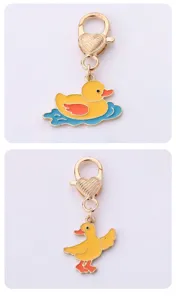 Detailed view of cute yellow duck metal keychain charm with heart clasp, golden alloy design.