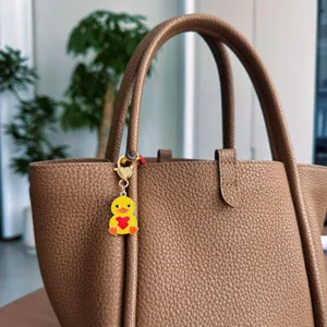 Cute cartoon yellow duck metal keychain bag pendant with red heart design for stylish accessories.