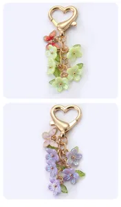 Nahaufnahme des süßen Blumen und Schmetterling Schlüsselanhängers mit goldenem Herzverschluss.