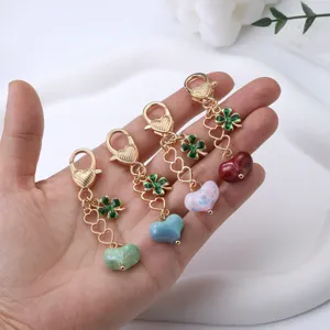 Porte-clés en alliage doré avec pendentifs en forme de cœur coloré et breloques trèfle.