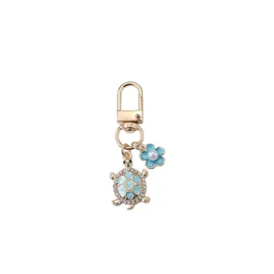 Metal turtle and flower bag charm keychain, stylish blue rhinestone keyring pendant accessory.