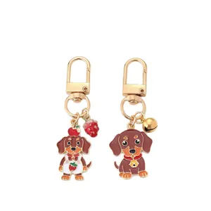 Cute enamel dachshund keychain featuring strawberry and bell charms, ideal bag accessory.