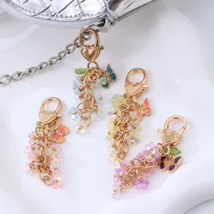 Ensemble de porte-clés dorés avec charms délicats de fleurs et papillons pour sacs.