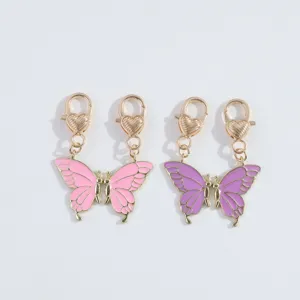 Zinklegering vlinderhanger detailweergave met hartvormige karabijnhaak roze en paars.