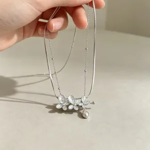 Doppelreihige silberne Schlangenkette mit glasiertem Blumen und Perlenanhänger Detail.