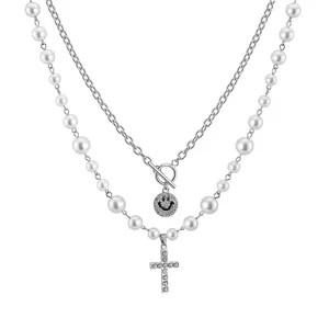Detailansicht der zweilagigen Perlenkette mit Strass-Kreuz und Smiley-Gesicht Anhängern.
