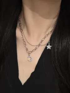 Detail shot of a double layer silver clavicle chain featuring moon and star crystal pendants.