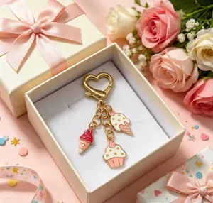 Gros plan d'un porte-clés cœur doré avec des pendentifs desserts mignons dans une boîte cadeau.