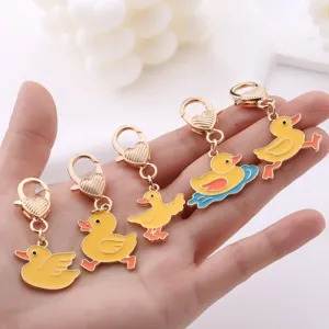 Cute yellow duck metal keychains set, cartoon enamel bag charms and accessories for women.