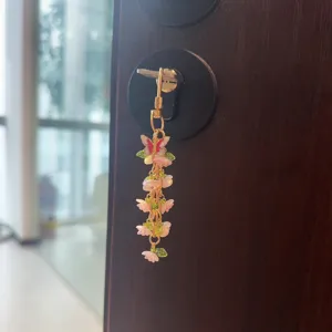 Exquisite butterfly and flower metal keychain detail, stylish bag charm pendant display.