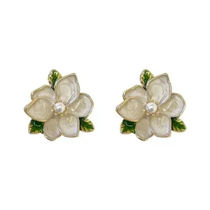 Vintage white enamel flower earrings with gold trim and pearl center, elegant botanical jewelry for women.