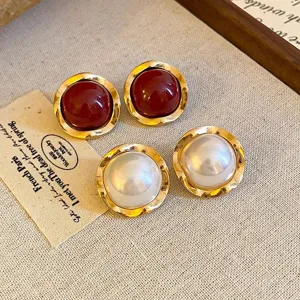 Detaillierte Nahaufnahme französischer Vintage-Ohrringe mit roten und weißen Perlen.
