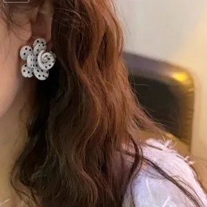 Elegante gepunktete Blumen Ohrringe mit modischem Wellenmuster für Herbst und Winter.