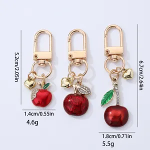 Cute apple and cherry metal keychain bag pendant with sparkling rhinestones and gold hardware.