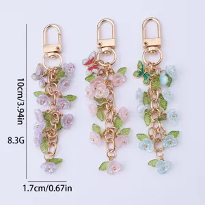 Metal keychain bag charm with translucent flower and butterfly pendants, stylish accessory.