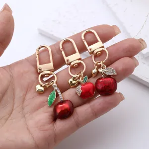 Cute fruit keychain featuring metal apple and cherry charms, perfect stylish bag accessory.