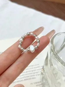 Detailed shot of a French vintage pearl and silver bead elastic ring, elegant and chic daily jewelry.