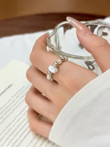 Close-up detail shot of the elegant pearl and silver beaded elastic ring, minimalist daily wear.