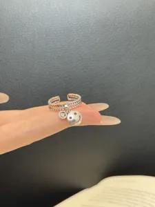 Primer plano detallado del elegante anillo abierto de plata con bonitos colgantes de sonrisa.
