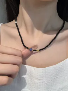 Schicke minimalistische schwarze Kristallperlenkette mit blauem Rissperle und filigranem Design.