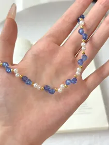 Nahaufnahme Detail der blau facettierten Kristall Perlen Halskette mit kleinen Goldperlen.
