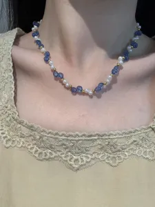 Nahaufnahme Detail der vintage Perlenkette mit blauen Kristallen und kleinen Goldperlen.