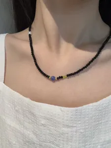 Nahaufnahme der handgemachten Perlen-Schluesselbeinkette mit schwarzen Kristallen und Stein.
