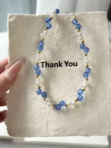 Detailansicht einer handgemachten Perlenkette mit blauen Kristallen und kleinen Perlen.
