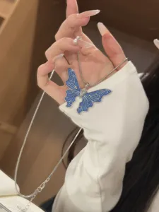 Detailaufnahme der eleganten blauen Schmetterling-Halskette, die feine Nuancen zeigt.