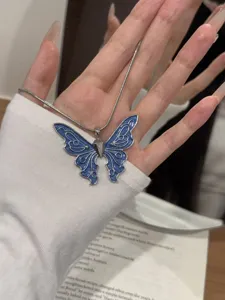 Detailansicht einer modischen blauen Schmetterling-Anhänger-Halskette mit Silberkette.