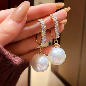 Elegante goldene Creolen mit glitzernden Steinen und hängenden weißen Perlen für den Alltag.