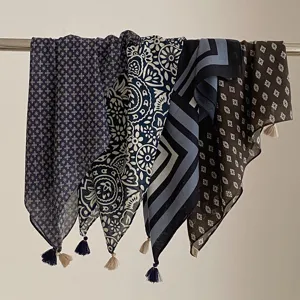 Detail de foulard carre retro a motif avec pompons elegants, accessoire de mode vintage.