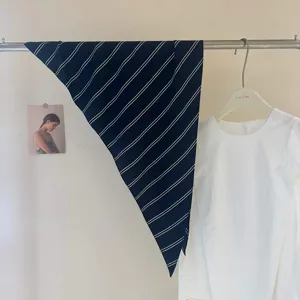 Vue détaillée du foulard triangulaire rayé coréen, tour de cou minimaliste et accessoire de sac.