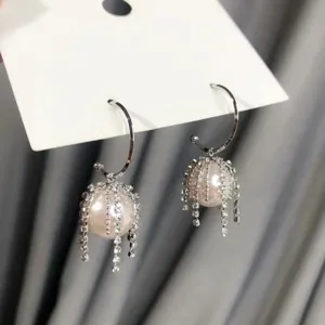 Nahaufnahme glänzender Perlen-Fransen-Creolen mit feinen Strass-Kristall-Details.