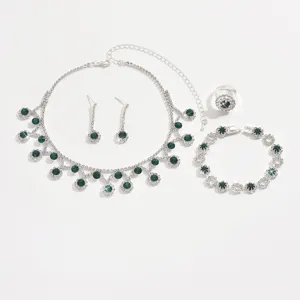 Gedetailleerd overzicht van groene strass sieraden met ketting, oorbellen, ring en armband.