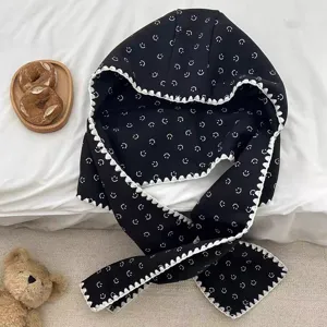 Vue détaillée de l'écharpe cagoule noire thermique avec imprimé smiley et bordure dentelle.