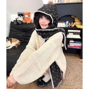 Vue détaillée d'une écharpe à capuche tricotée d'hiver pour femme avec imprimé smiley et pull.