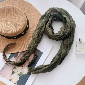 Green gradient tie-dye scarf detail, elegant styling with straw hat and perfume bottle.