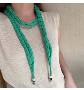 Detail view of the vibrant green knitted hollow long scarf featuring delicate beaded ends.