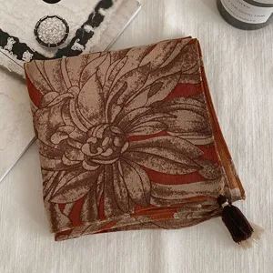 Gros-plan détail d'un foulard carré à imprimé floral vintage avec gland, accessorio rétro élégant.