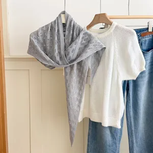 Detailed close-up view of the stylish gray hollow-out knit triangular scarf in outfit.