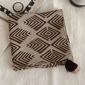 Vue détaillée du foulard carré à motif géométrique vintage avec gland, accessoire chic.